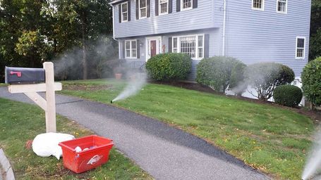Residential Irrigation: Sprinklers watering a home lawn.